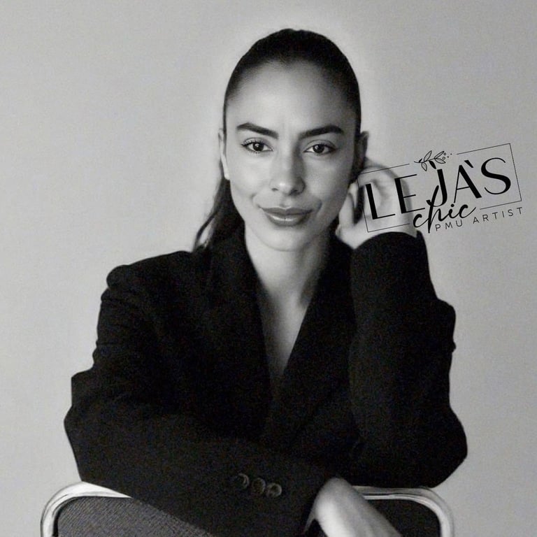 Black and white portrait of a woman in a dark blazer posing for a professional headshot against a neutral background